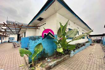 Grande proprit de 2.400m sur la route principale idale pour tous projets immobiliers et dote dun plusieurs btiments  dmolir. Gombe proximit du Lyce RenDescartes