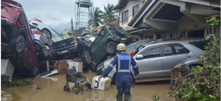 Un sauveteur passe devant des voitures empilées emportées par les inondations au plus fort du typhon Kalmaegi à Cebu, aux Philippines, le 4 novembre 2025